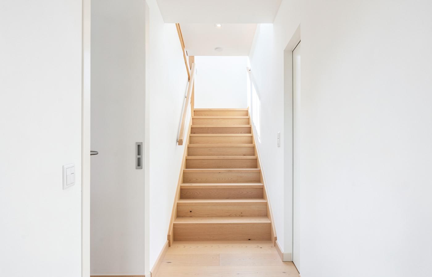 Heller, sauberer Hausflur mit Holztreppe nach der Hausreinigung